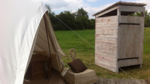 un toilette sec à coté d'une tente