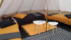 Des lits installés sous une tente dans le cadre de notre formule bivouac